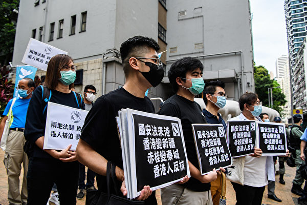图为5月22日，香港民众举着标语牌，反对中共对香港强加国安法。(Anthony WALLACE / AFP)