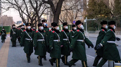 大疫冲击政局，涉北京防务的军方关键人物接连异动。图为一队军警戴着口罩行走在北京街头。（图片来源: NICOLAS ASFOURI/AFP via Getty Images）