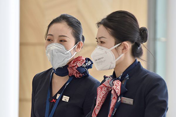 图为1月25日东方航空公司的机组人员从上海抵达悉尼机场。（AFP/Getty Images）